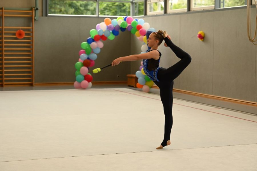 Eine Gymnastin zeigt eine Übung mit Keulen.