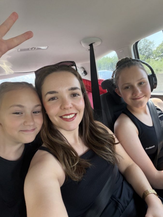 Eine Frau und zwei Mädchen machen Selfies im Auto.